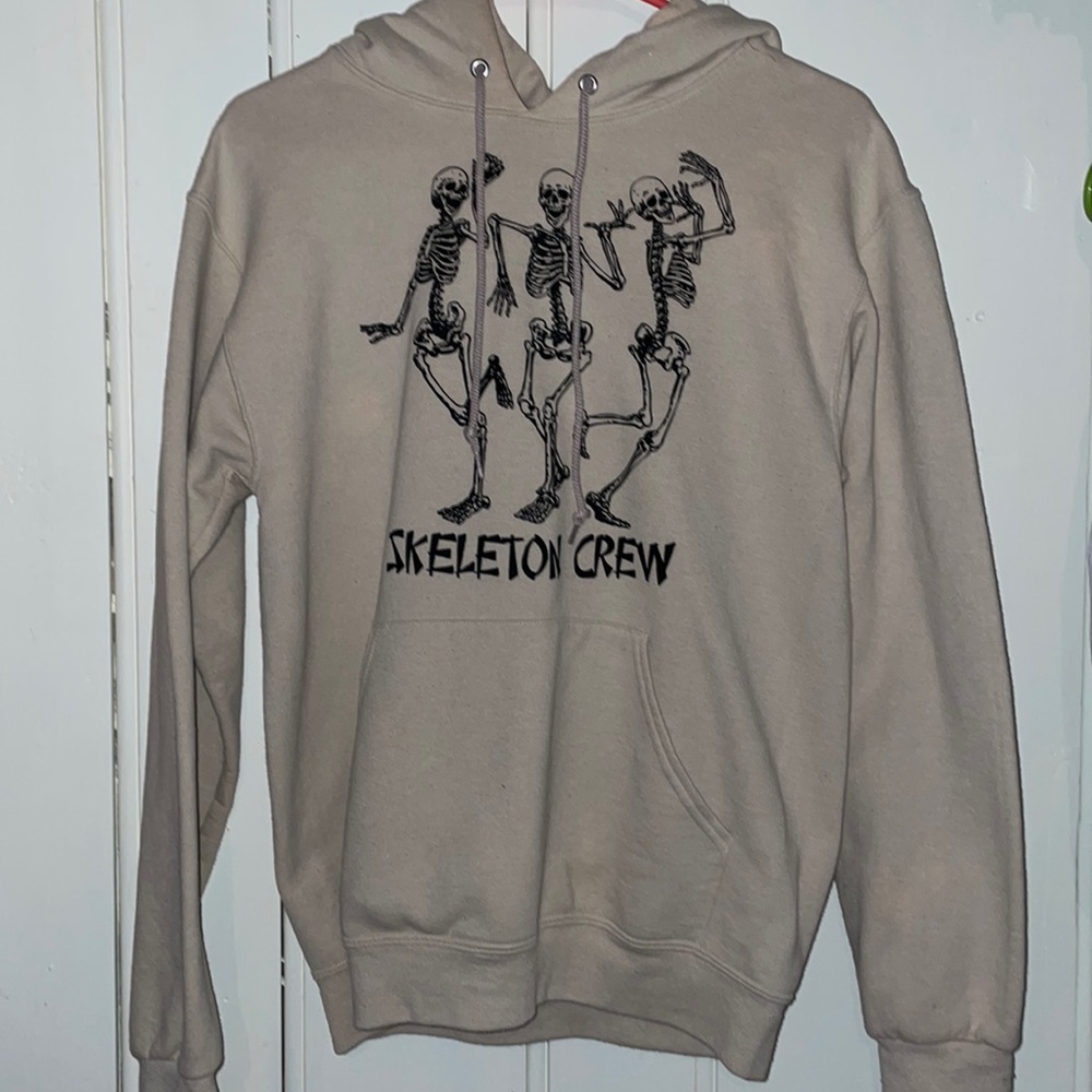 Small woman’s cream colored hoodie with a Halloween design on it.